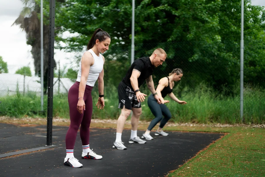 Athletes practicing explosive jumping movements outdoors