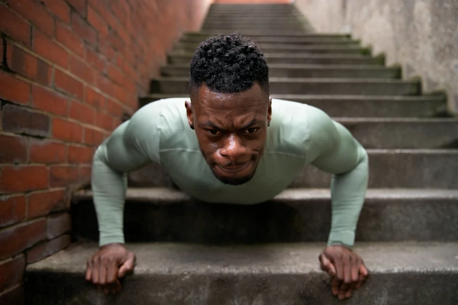 Athlete performing a push-up on concrete steps